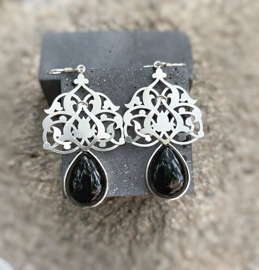 Handmade sterling silver openwork earrings with floral pattern and teardrop black onyx drops; hook closure; satin-matte finish.