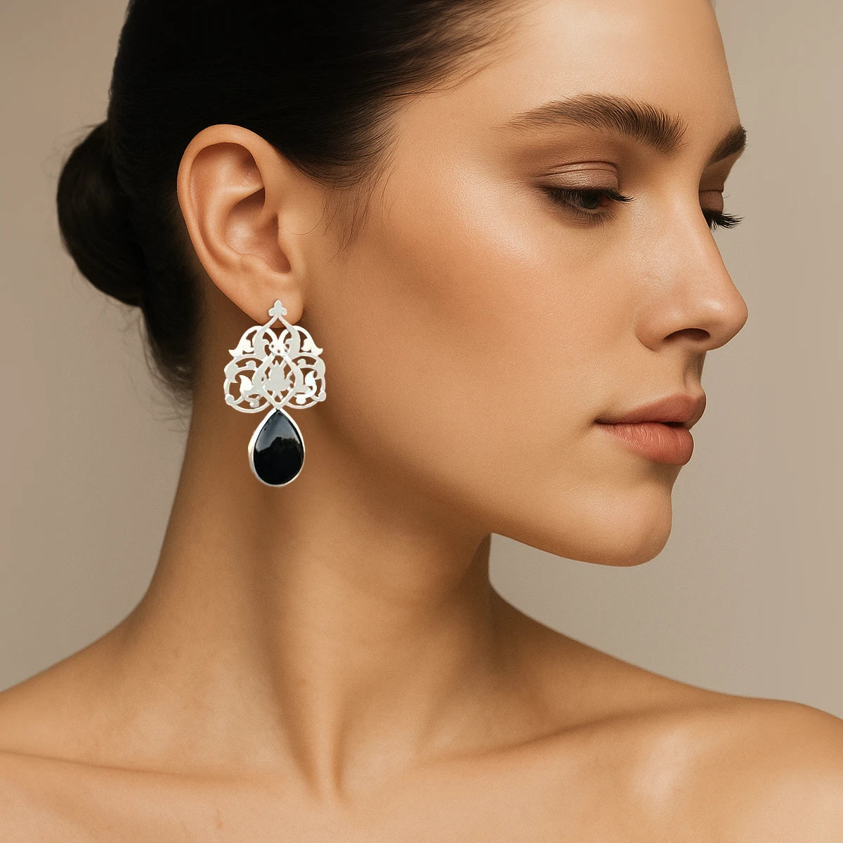 model wearing Handmade sterling silver openwork earrings with floral pattern and teardrop black onyx drops; hook closure; satin-matte finish.