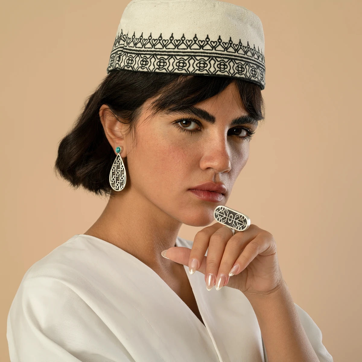 model wearing handmade silver teardrop earrings with oxidized parts and geometric patterns decorated with turquoise