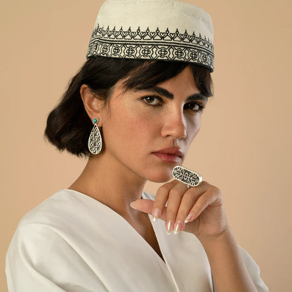 model wearing handmade silver teardrop earrings with oxidized parts and geometric patterns decorated with turquoise