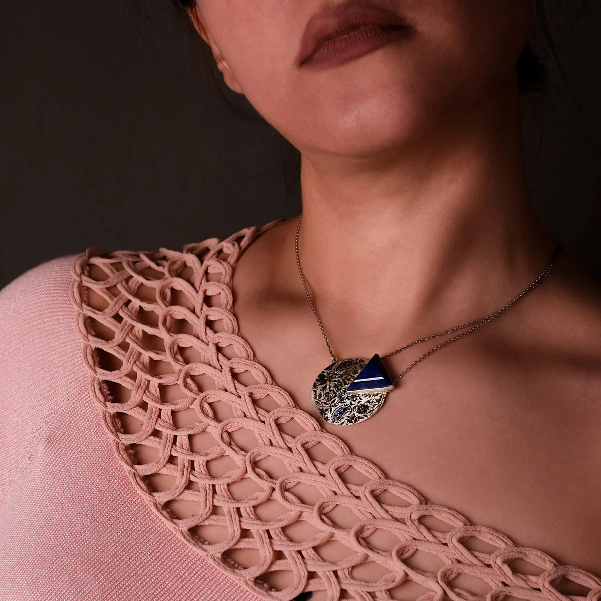 model wearing round circle handmade pendant necklace with lapis lazuli and paisley and floral patterns