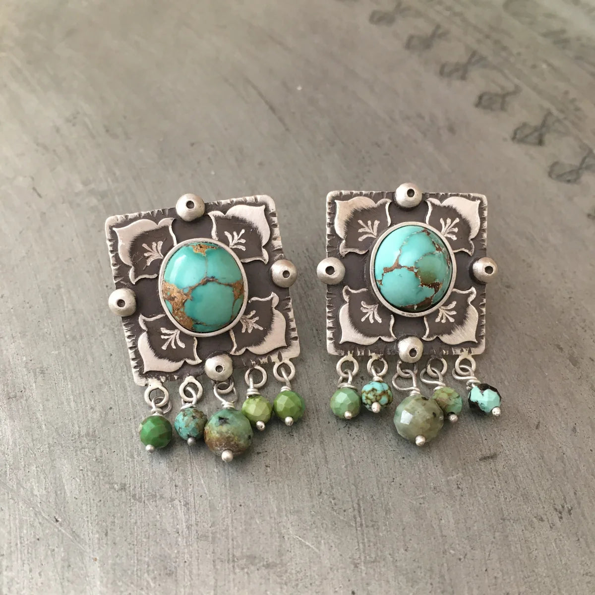 handcrafted oxidized silver stud earrings decorated with turquoise gemstones and floral motifs